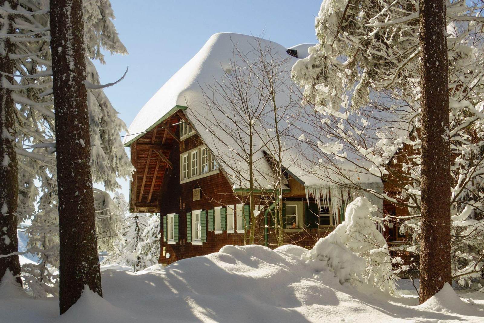 Holzhaus mit Schnee auf dem Dach