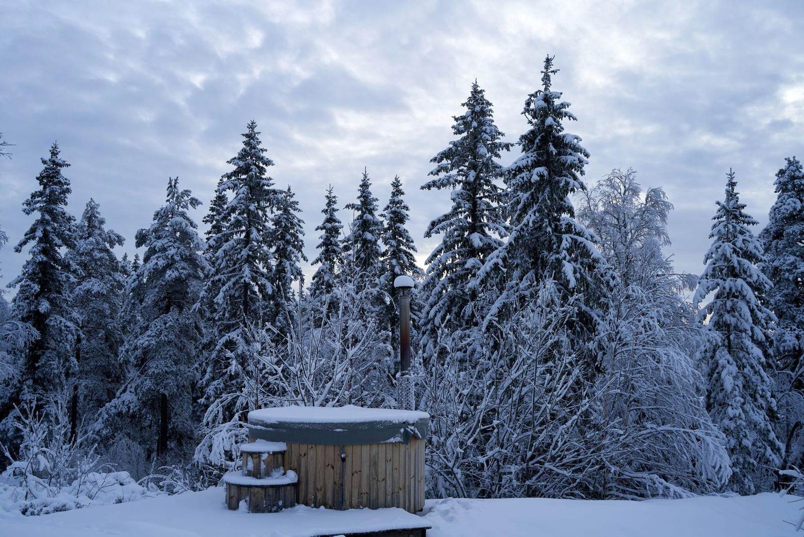 Hot Tub aus Holz im verschneiten Wald