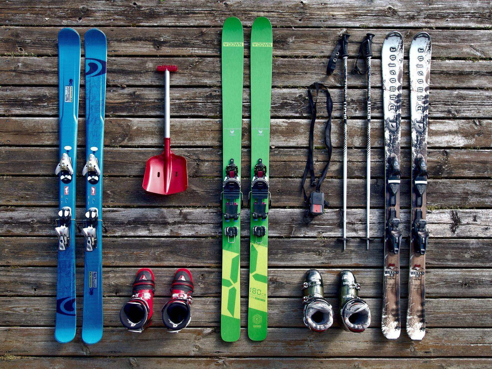 Ski, Schuhe und Stöcke auf Holzboden ausgelegt