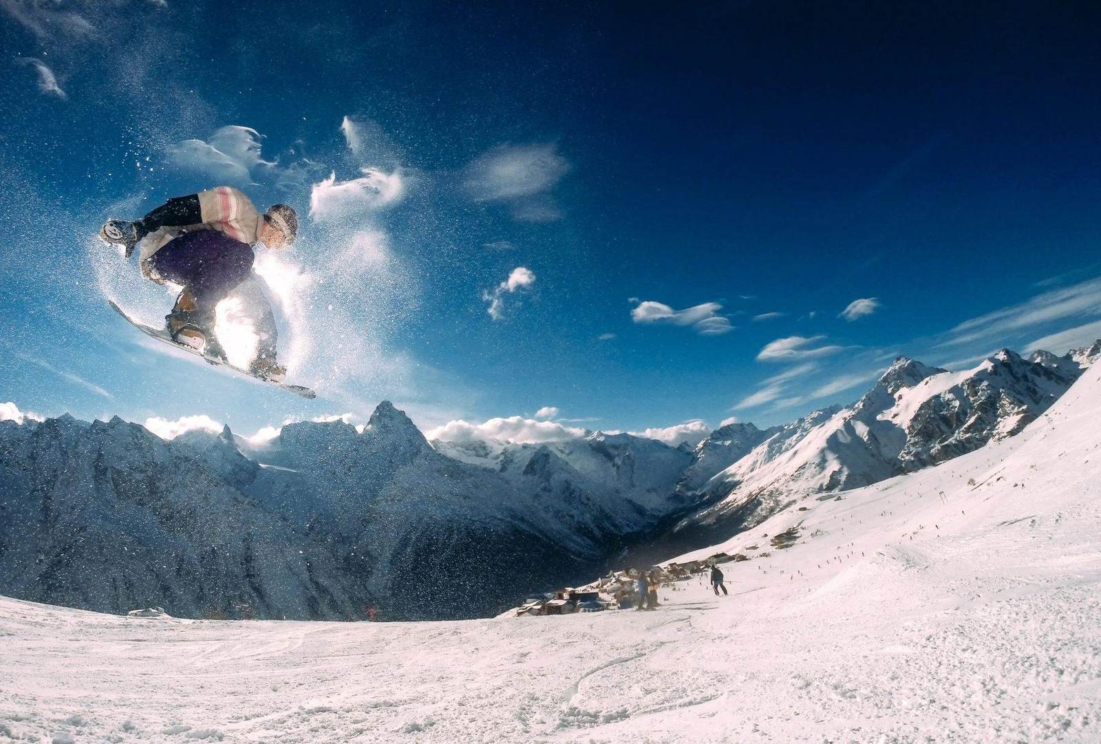 Snowboarder in der Luft vor Bergkulisse