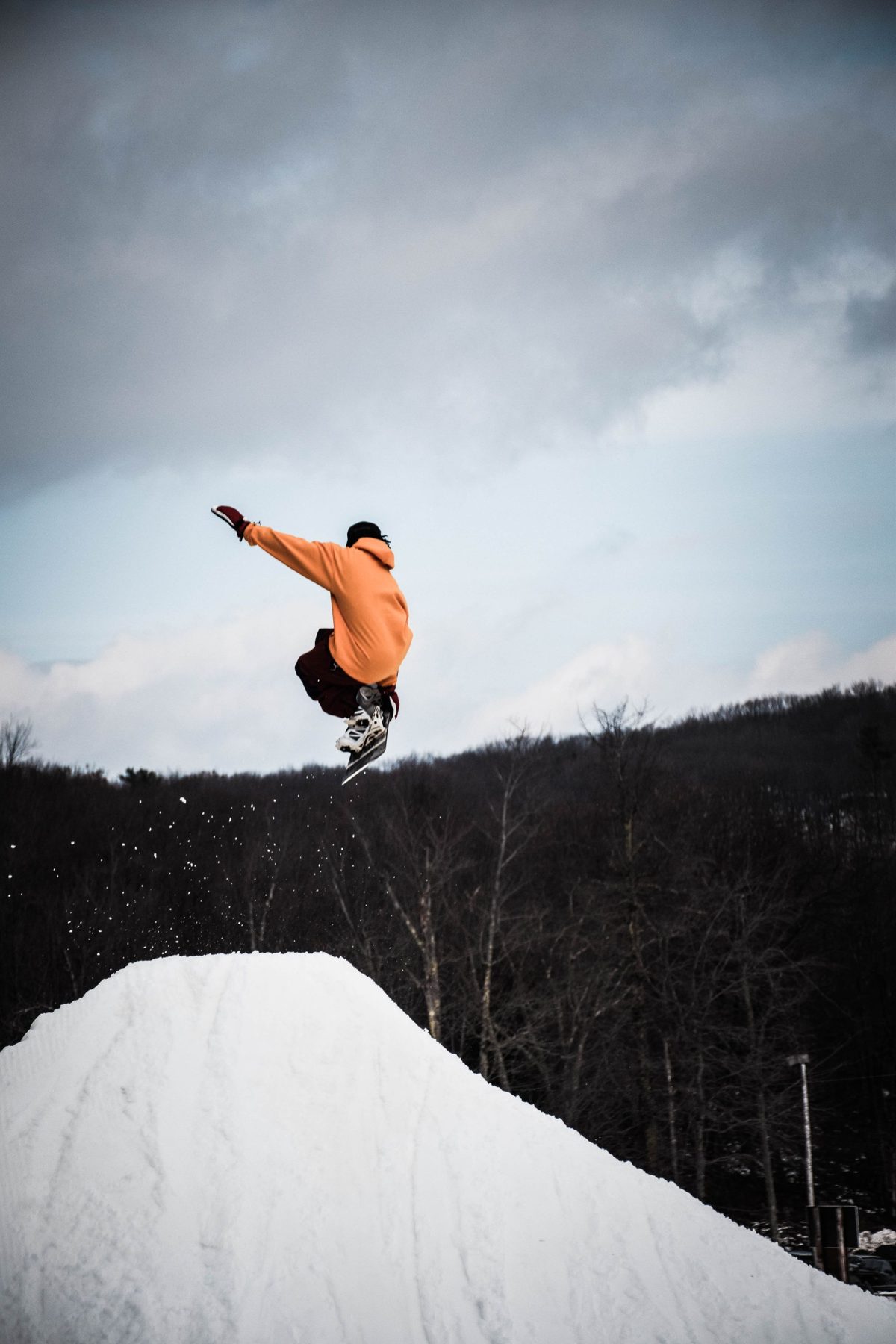 Ein Snowboarder springt vor grauem Himmel
