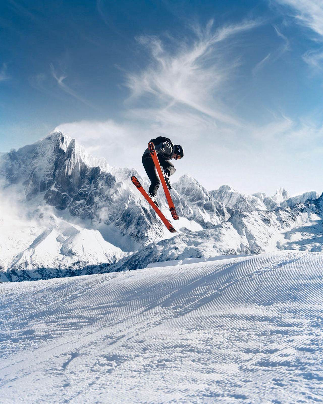 Skifahrer springt über eine verschneite Kuppe