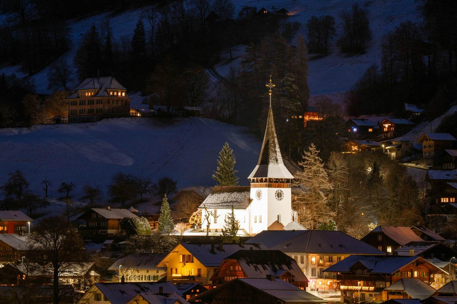 Dorf mit Kirche bei Nacht im Schnee