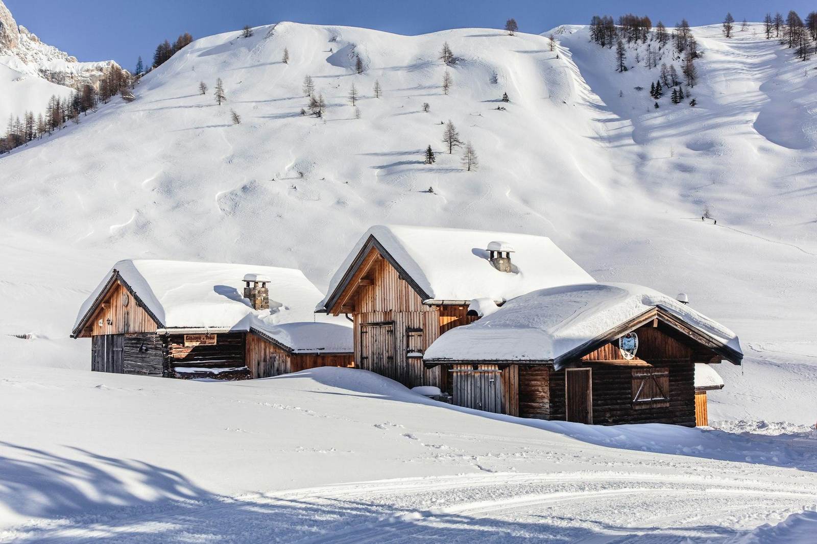 Holzhäuser auf einem verschneiten Hang